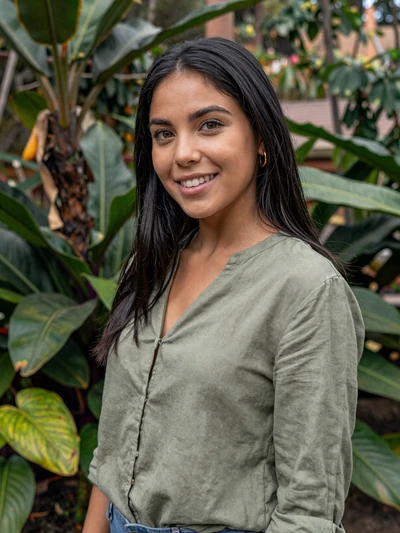 Andrea, 25-year-old Colombian woman in Medellín botanical garden wearing a green blouse